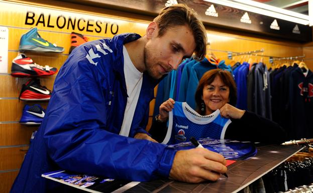 Javi Vega firma una foto de la afición, que será expuesta en la tienda
