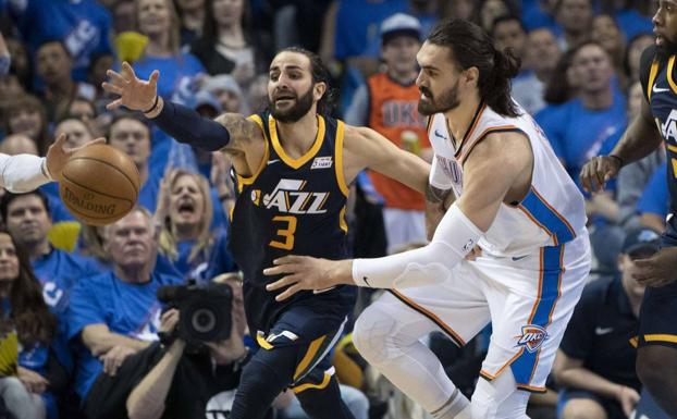 Ricky Rubio lucha por conseguir el balón ante Steven Adams./Afp